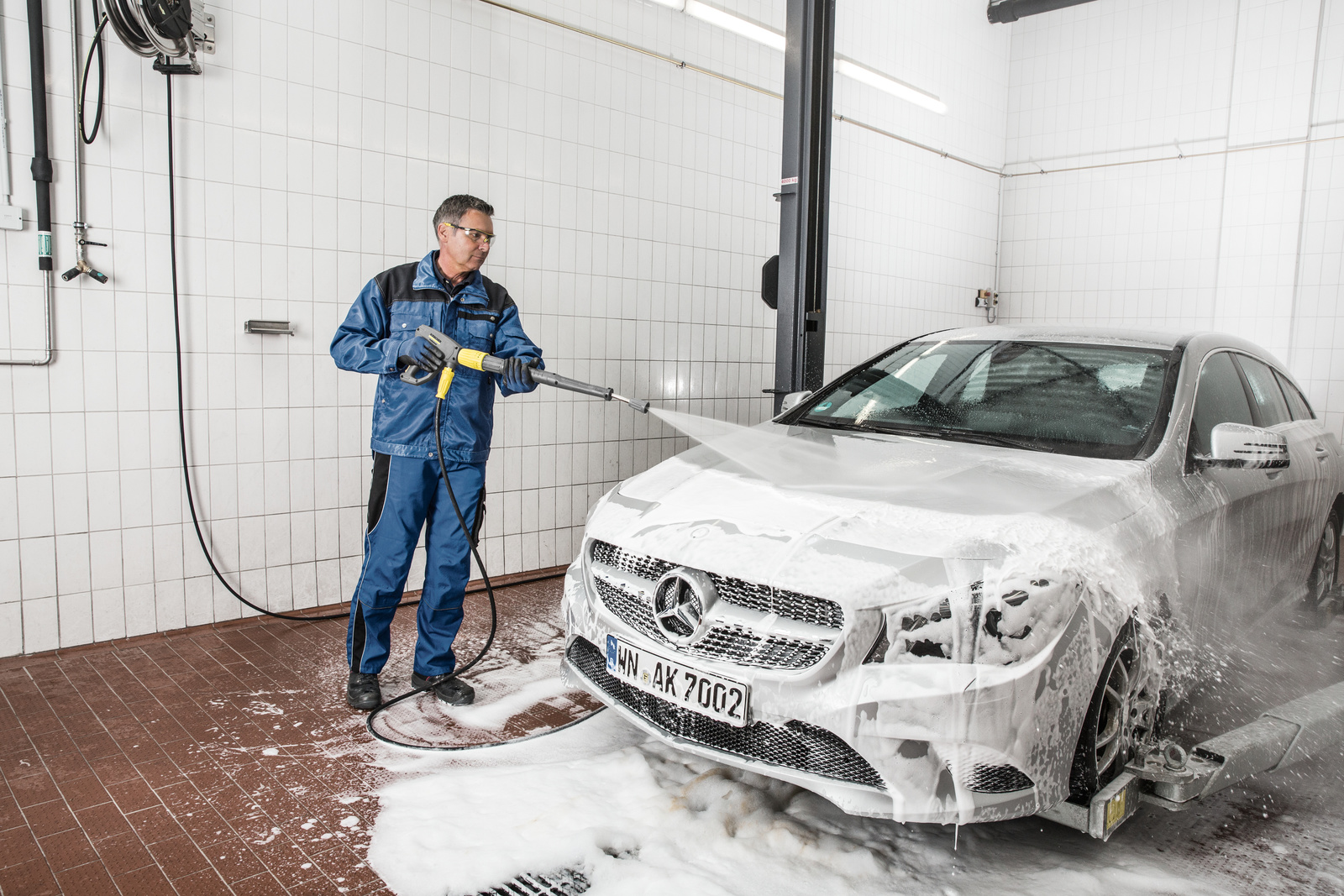 Auto wordt handmatig gewassen in een autowasstraat via hogedrukreiniging.