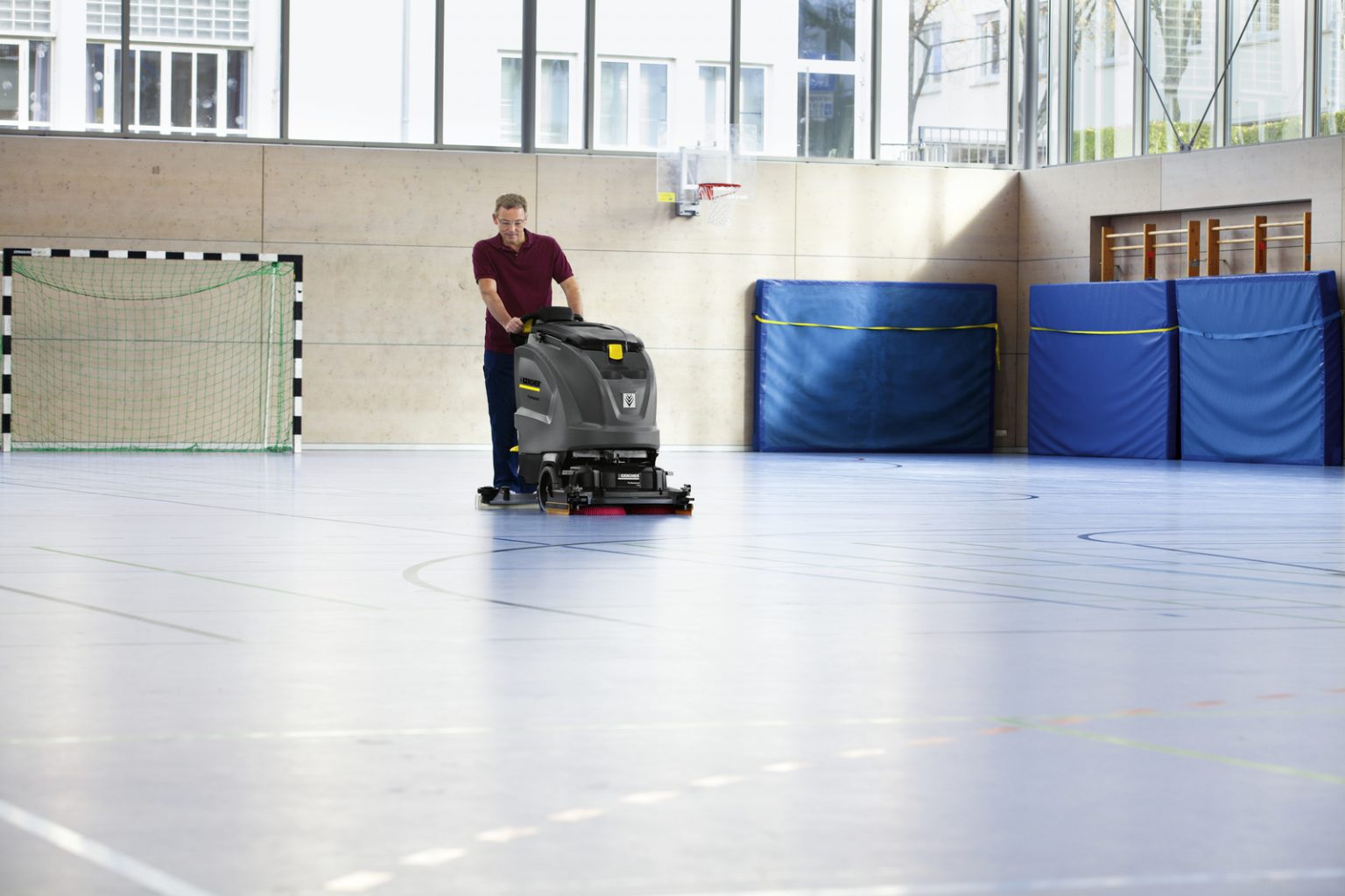 Schrob-/zuigmachine reinigt de vloer van een sporthal
