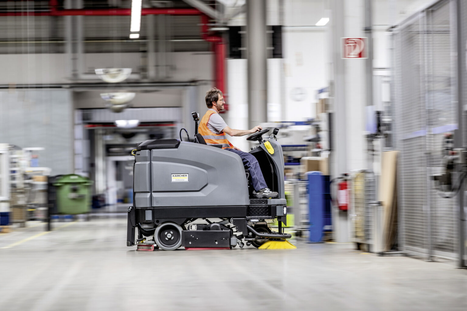 Opzit-schrob-/zuigmachine in een industriehal